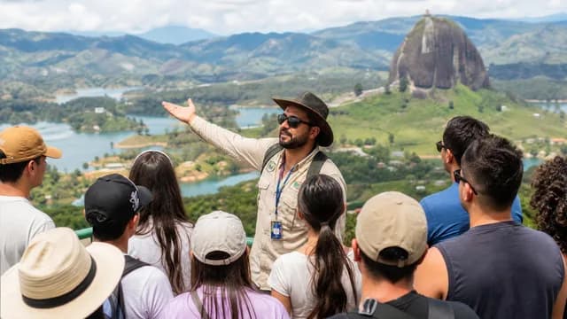 Guía turístico certificado explicando el paisaje a un grupo en el mirador de Guatapé
